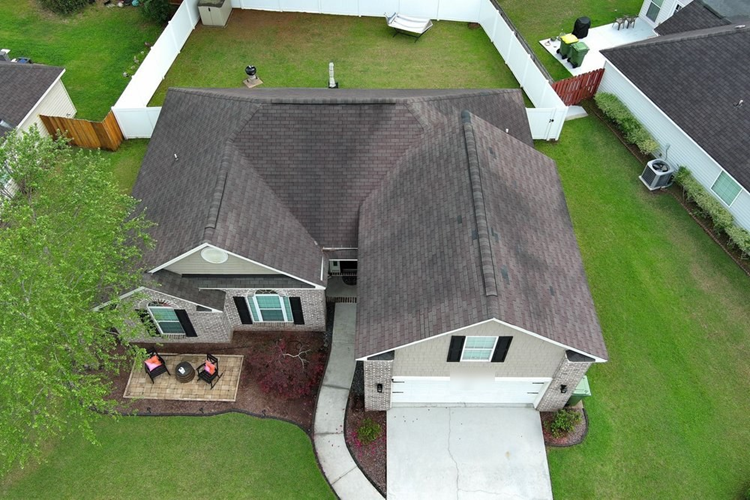 Before an aging roof with dark algae streaks and worn shingles.